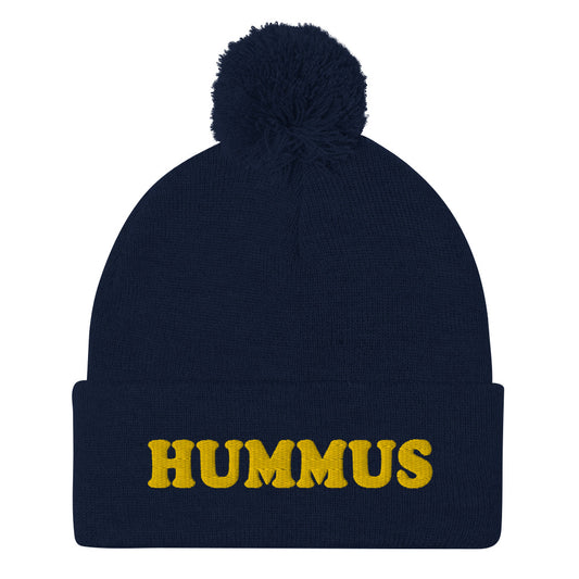 Navy Beanie with Hummus Embroidered on the front in yellow - Do you love hummus? Looking for a funny gift for a foodie? This warm and cozy, embroidered beanie is just what you need. It's a classic pom pom beanie with "HUMMUS", embroidered on the front. The perfect funny beanie for hummus lovers and foodies of all kinds. Celebrate your favorite foods in our funky foodie apparel.