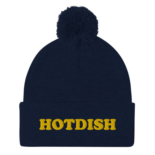 'HOTDISH' Pom-Pom Beanie. This funky foodie beanie is a warm and cozy hat for cold weather. It's a classic beanie with a pom pom and a unique hotdish embroidery. This funny beanie is unique and weird and a perfect funny hat for a unique gift idea. Ideal for foodies who love hotdish and funky foodie beanies.